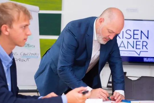 Krisenplaner Karl Dieter Brückner beim Erarbeiten eines Plans für das Kontinuitätsmanagements mit Mitarbeitern eines Unternehmens